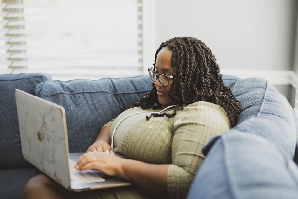 a woman sitting on a couch working on a laptop computer-email design
