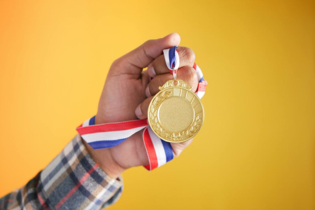 the hand of a man holding a medal