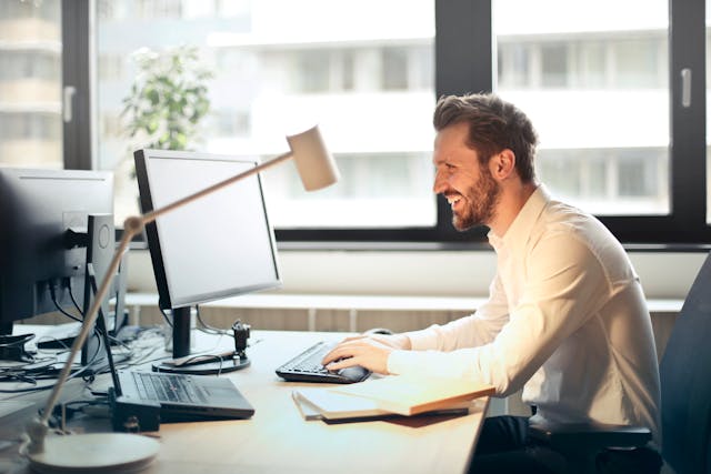 a man smiling at his computer