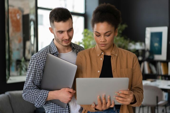 a man and woman looking at a laptop