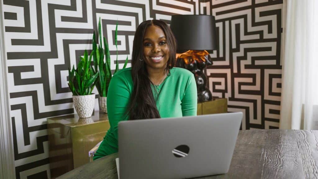 A woman is smiling while working on a laptop.
email marketing for business