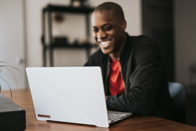 a man smiling at funny email subject line on his laptop