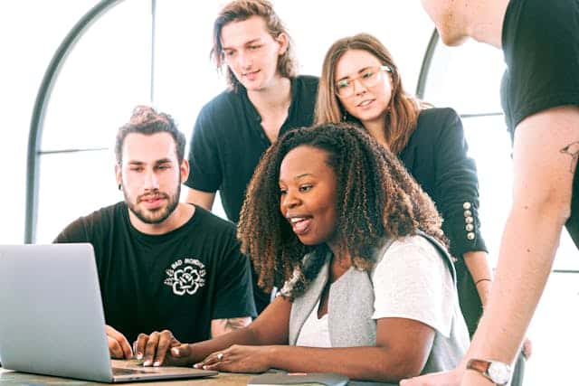 a group of people staring at a laptop