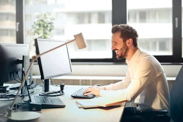 a man smiling at his computer-email automation tips