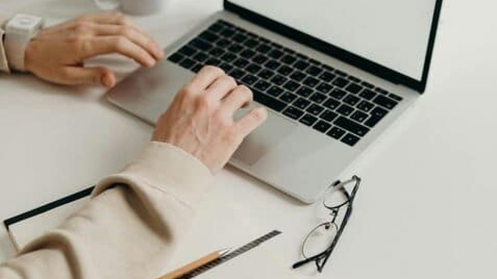 hands typing on macbook